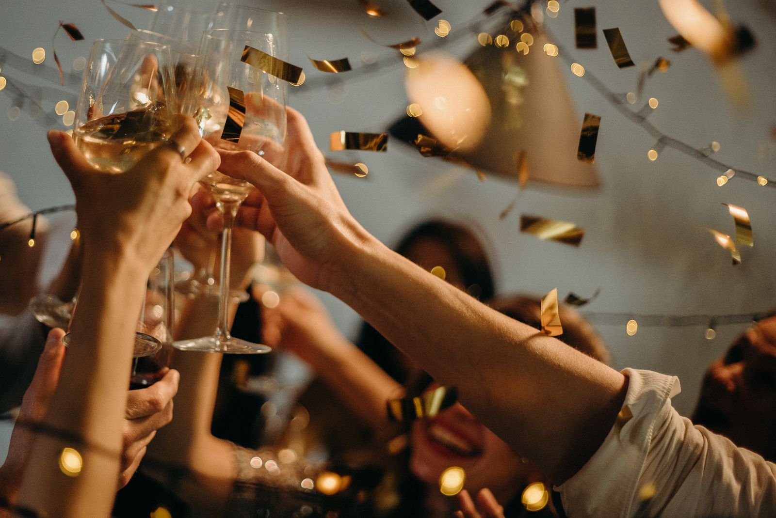 Guests raising champagne glasses amid gold confetti