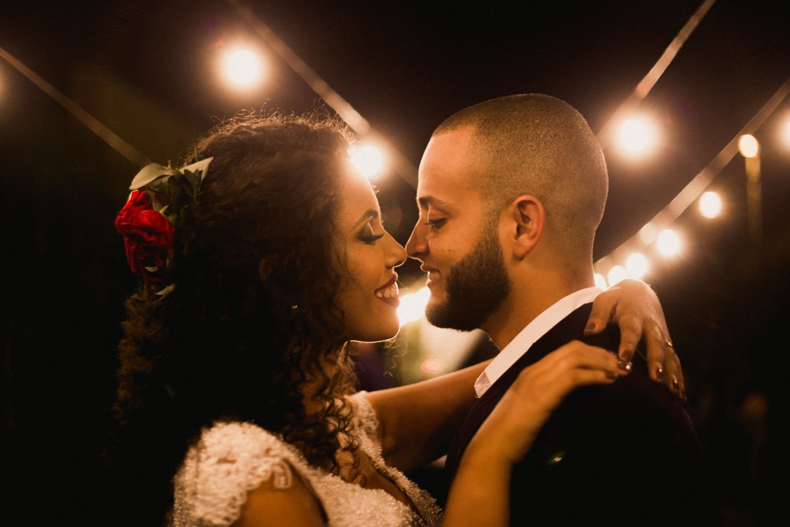 Nose to nose beneath the string lights at night